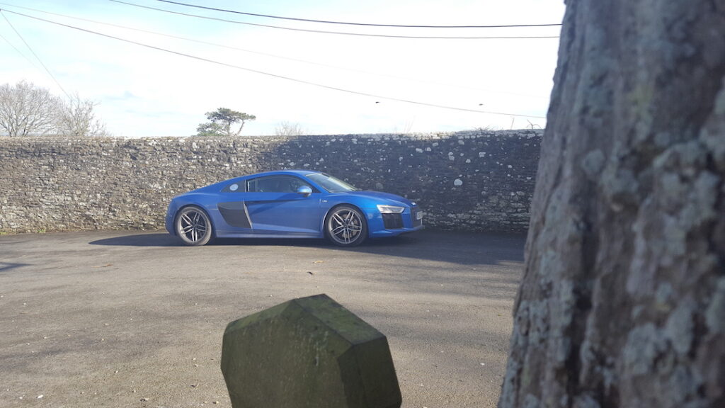Side view of a blue Audi R8 outside on a sunny day