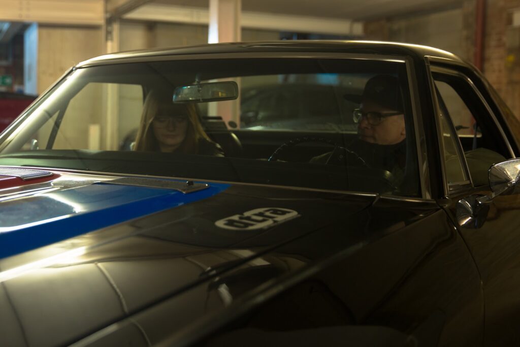 Marnie Brinkworth, in the passenger seat, and her dad sit inside one of his cars