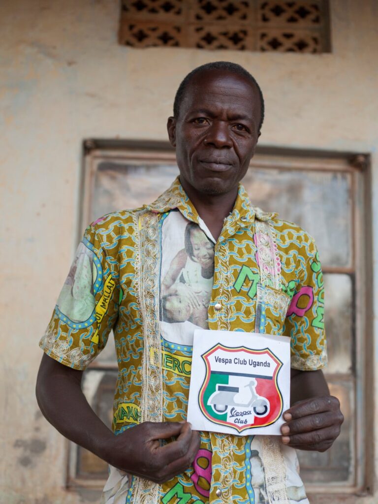 A member of the Vespa Club Uganda shows off their badge