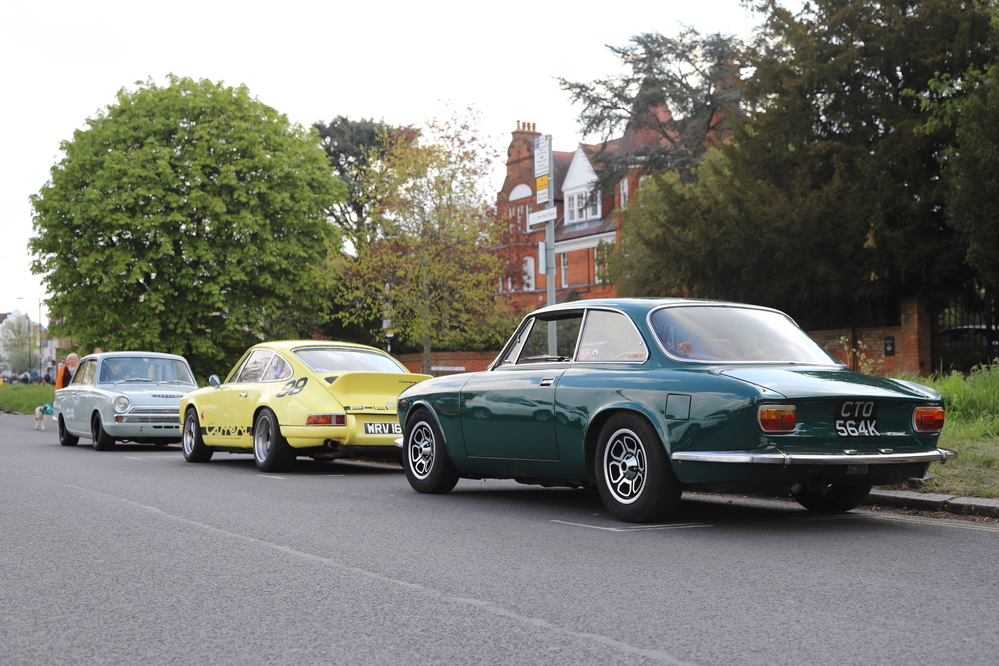 Three 'Wacky Racers' cars lined up on the side of a street