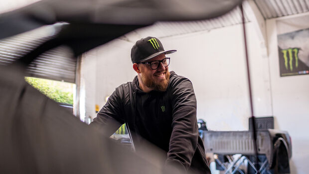 Baggsy is all smiles inside a garage workshop