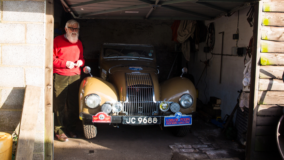 John Manley in a garage beside his Allard